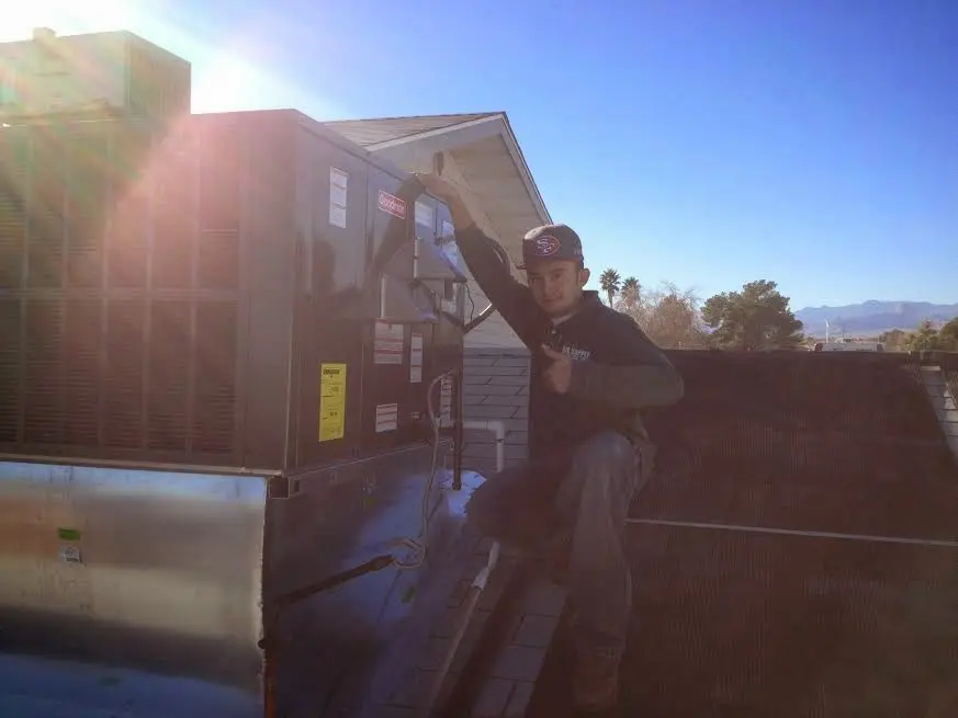 HVAC technician performing Heat Pump Repair on a rooftop unit in Severna Park